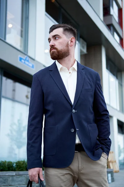 Vonzó szakállas fiatalember klasszikus öltönyben táskával — Stock Fotó