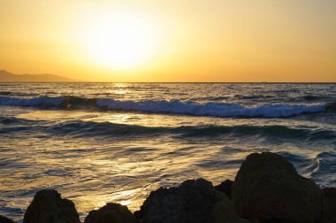 Deniz dalgası yakın, alçak açılı, güneşli bir çekim.