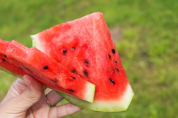 Hand met twee stuk van watermeloen — Stockfoto
