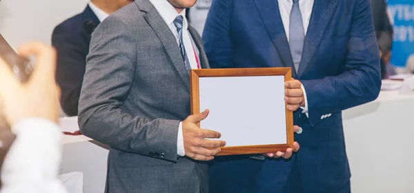 Concede um diploma de outro homem em uma reunião de negócios — Fotografia de Stock
