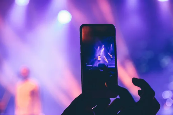 Kobieta robi zdjęcia w telefonie na koncercie — Zdjęcie stockowe