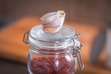 Sarımsak ve baharat ahşap arka plan üzerinde cam kavanozlara 