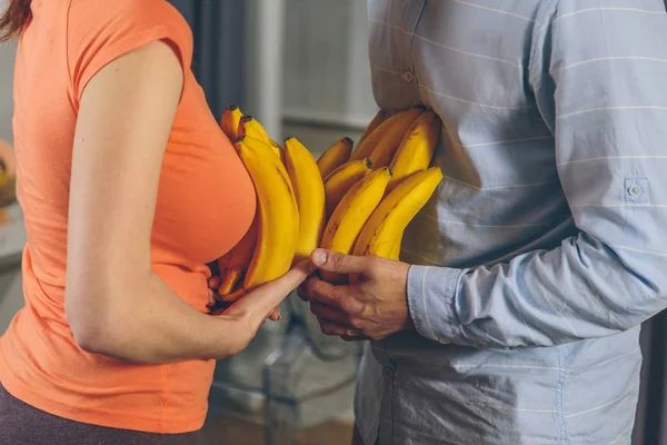 man and woman holding bananas