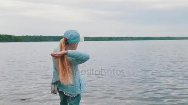Het Meisje Gooit Een Steen Het Water — Stockvideo