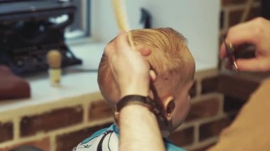 Kuaför berber içinde küçük bir çocuk keser. Arkadan Görünüm