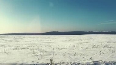 güneşli bir öğleden sonra Frost alanında karla kaplı çimlere. hareket eden bir arabanın penceresinden ateş