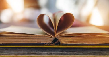 bir kalp şeklinde sayfalarıyla birlikte açık bir eski kitap