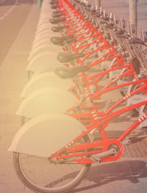 Şehir caddesinde otomatik bisiklet parkı. Yeni kaliteli bisikletlerin kiralama hizmetleri. Bir sıra parlak kırmızı ve siyah bisiklet.