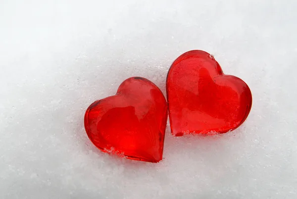 Coeurs rouges décoratifs sur fond de neige . — Photo