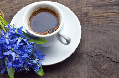 Kahve fincanı ve eski rustik ahşap masaya ilk bahar çiçek buketi. Bahar sabah, Kahvaltı, Günaydın kavramı.