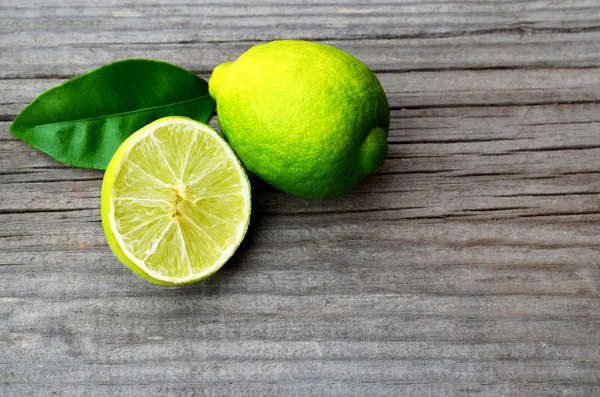 Frischer reifer Bio-Kalk auf altem Holztisch. Limettenfrucht.Ernährung, gesundes Essen oder Aromatherapie-Konzept. Kopierraum, selektiver Fokus. — Stockfoto