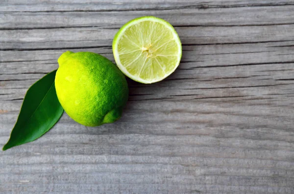 Verse rijpe biologische kalk op oude houten tafel. Kalk fruit. Dieet, gezonde voeding of aromatherapie concept. Kopie ruimte, selectieve aandacht. — Stockfoto