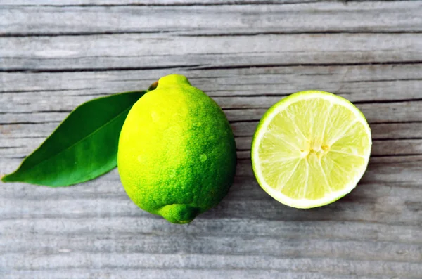 Calce fresca biologica matura su vecchio tavolo di legno.Frutta di calce. Dieta, cibo sano o concetto di aromaterapia. Copia dello spazio, messa a fuoco selettiva . — Foto Stock