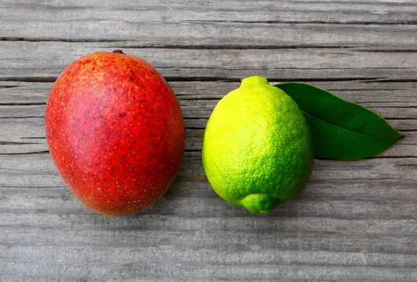 Taze olgun organik mango ve kireç eski ahşap masa üzerinde. Mango ve kireç. Tropikal meyve. Diyet ya da sağlıklı gıda kavramı.