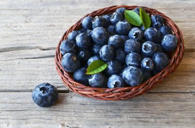 Taze yaban mersini eski ahşap zemin üzerinde bir sepet içinde aldı. Blueberry.Bilberry.
