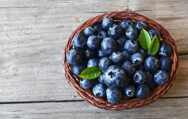 Taze yaban mersini eski ahşap zemin üzerinde bir sepet içinde aldı. Blueberry.Bilberry.