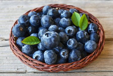 Taze yaban mersini eski ahşap zemin üzerinde bir sepet içinde aldı. Blueberry.Bilberry.