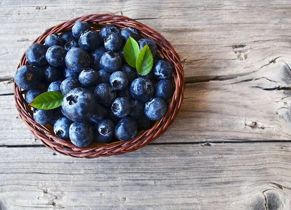 Vers geplukt bosbessen in een mandje op oude houten achtergrond. Blueberry.Bilberry. — Stockfoto