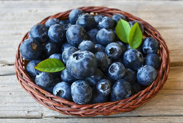 Taze yaban mersini eski ahşap zemin üzerinde bir sepet içinde aldı. Blueberry.Bilberry.
