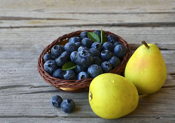 Frische Blaubeeren und reife Birnen auf einem rustikalen Holztisch. Blaubeeren und Perlen. Gesunde Ernährung, Ernährung und Ernährungskonzept. — Stockfoto