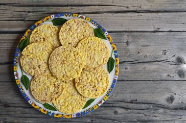 Eski ahşap masa üzerinde bir plaka üzerinde tam tahıl crispbreads ıspanaklı bırakır. Kahvaltılık crispbreads. Pirinç ve Mısır crispbreads.