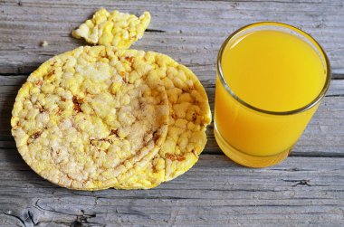 Bütün tahıl crispbreads bardak suyu eski ahşap tablo ile. Kahvaltılık crispbreads. Pirinç ve Mısır crispbreads. Sağlıklı Kahvaltı veya diyet kavramı.