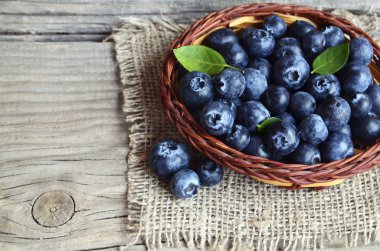 Taze yaban mersini eski ahşap zemin üzerinde bir sepet içinde aldı. Taze organik yaban mersini. Bilberries.Healthy yeme, vegan diyet veya çiğ gıda kavramı.