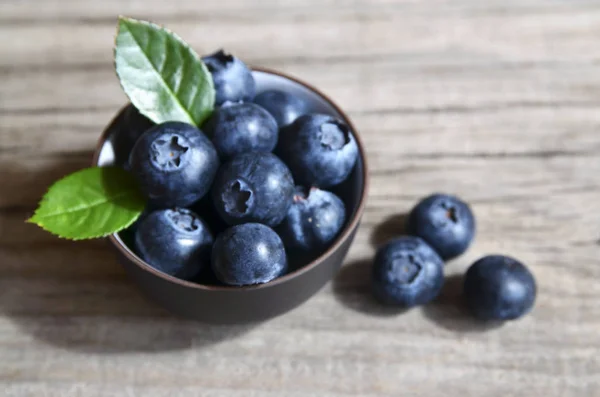 Frische Bio-Blaubeeren in einer Glasschüssel auf altem Holzgrund. bilberries.gesunde ernährung, vegane kost, ernährungs- und ernährungskonzept. — Stockfoto
