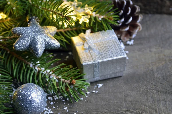 Noel dekorasyonu ile çam ağacı, gümüş hediye kutusu, çelenk ışık, oyuncaklar ve çam kozalakları eski ahşap zemin üzerinde. Kış tatil, Merry Christmas, Happy New Year kavramı. 