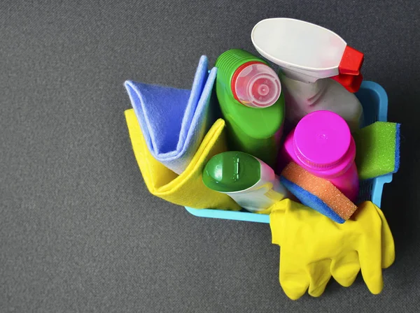 Colorful set of cleaning supplies in a blue basket with copy space.Spring cleaning,housework, housekeeping or household concept.Top view.Selective focus.