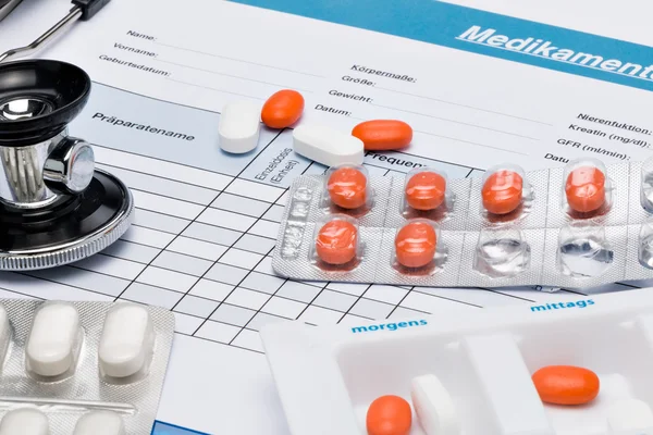 Plano de medicação (em alemão), com comprimidos e estetoscópio — Fotografia de Stock