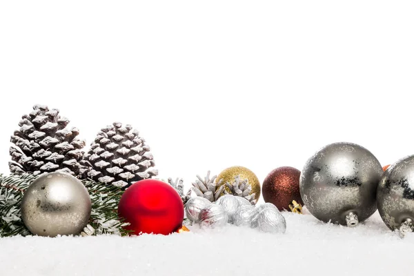 Tannenzapfen und Christbaumkugel im dekorativen Schnee — Stockfoto