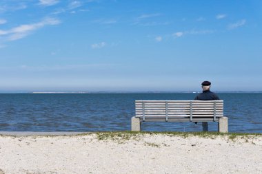 Deniz kenarında bir bankta oturan ihtiyar