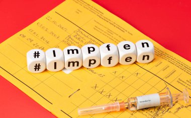Uluslararası aşı kartında aşı olan bir şırınga. hashtag, aşı (Aşı için Impfen, Germnan)