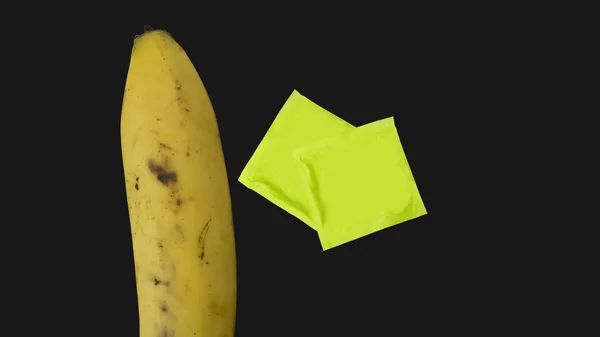 Metafora banán ruka drží kondom gumové koncept — Stock fotografie