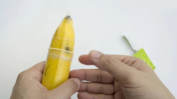 隐喻香蕉手拿着避孕套橡胶的概念 — 图库照片