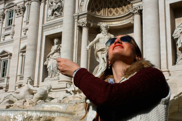 Девушка бросает монету в знаменитый фонтан Треви в Риме, Италия . — стоковое фото