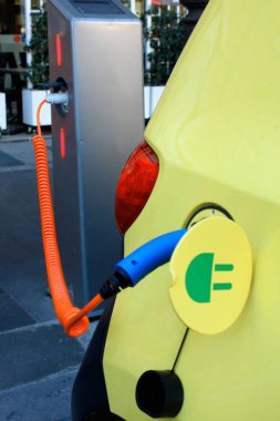 Elektrik kablosu prize takılı bir elektrikli arabayı şarj etmek....