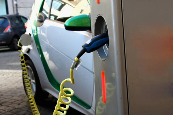 Chargement d'une voiture électrique avec l'alimentation du câble d'alimentation branché. — Photo