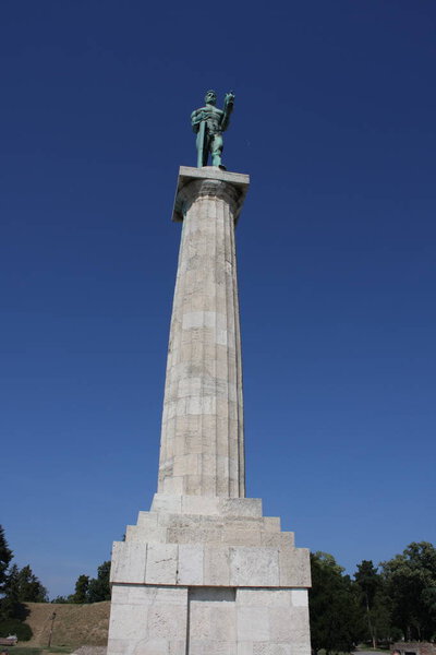 Памятник скульптуре Белграда Виктора из бронзы, расположенный в парке Калемегдан с видом на реку Сава и Земунский район, Белград, Сербия
.