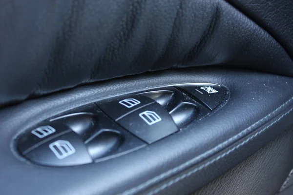 Car interior details of door handle with windows controls and adjustments. Car window controls and details — Stock Photo, Image