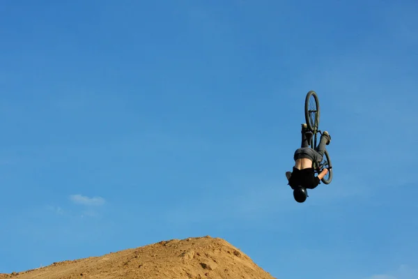 Uma pessoa em julgamento bicicleta voando sobre a câmera — Fotografia de Stock