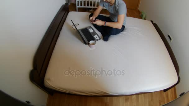 Uomo Impostazione Sul Letto Con Suo Computer Portatile Studio — Video Stock