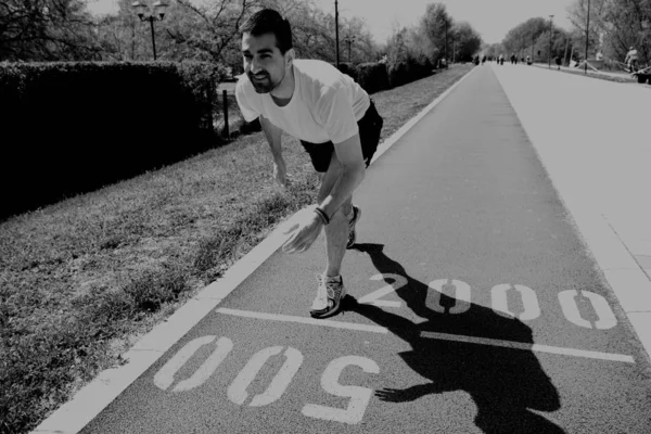 Hombre atlético en pista comenzando a correr — Foto de Stock