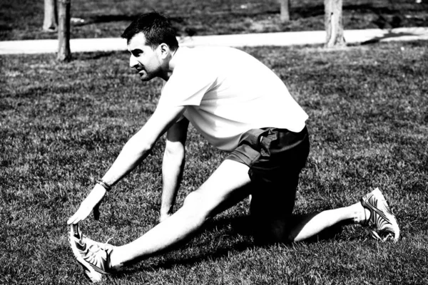 Hombre en el parque haciendo ejercicios de estiramiento — Foto de Stock
