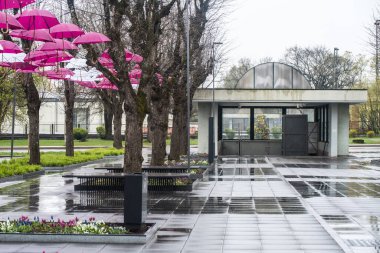 Dev şehri kırmızı ve beyaz şemsiyelerle süslenmiştir. Dev. - Letonya. 2 Mayıs 2020.