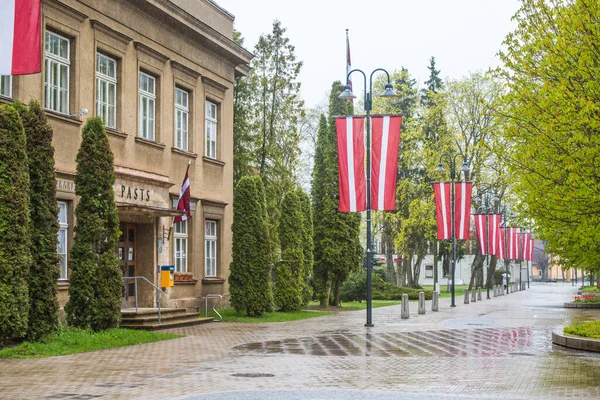 Trollstaden är dekorerad med nationella flaggor. Postkontor. Odjuret. Lettland. 2 maj 2020. — Stockfoto