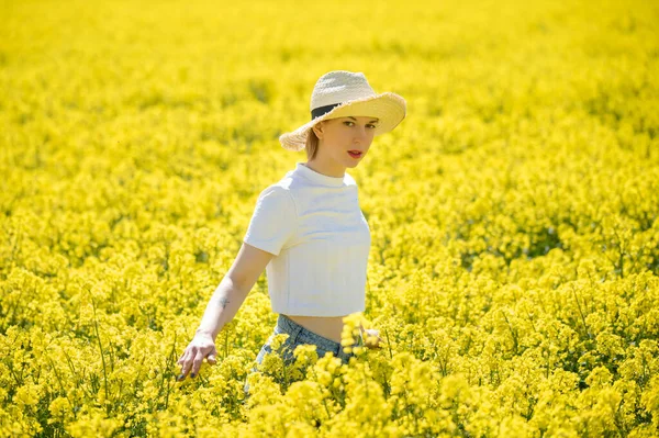 Une jeune femme se tient dans un champ de viol — Photo