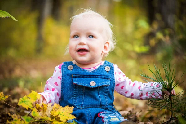 Happy baby girl smát a hrát na podzim v lese — Stock fotografie