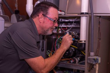 Hvac Tech bir gaz ocağına yeni bir parça yüklüyor 